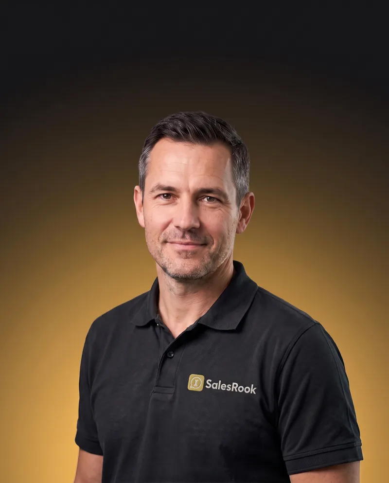 Sterling, co-host of The Rook Report Radio Show, in a black SalesRook polo against a black-to-gold gradient